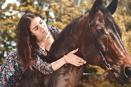 漂亮的西班牙黑发美女在森林里骑马时给了她一个拥抱 爱动物的概念 爱马图片
