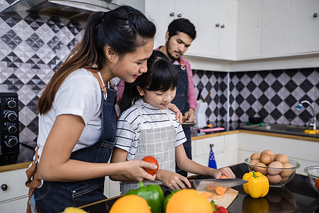 亚裔家庭正在做饭 家长在教他们游泳厨房女儿孩子午餐围裙母亲童年乐趣沙拉爸爸图片