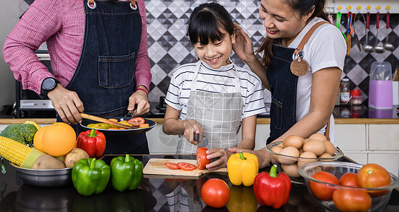 亚裔家庭正在做饭 家长在教他们游泳桌子父母厨房母亲食物孩子们女儿乐趣父亲房子图片