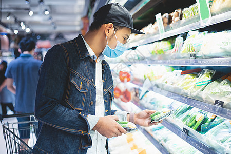 亚裔男子在乔维期间购买和购物食品以囤积疾病产品杂货暴发篮子库存大车杂货店男人市场图片