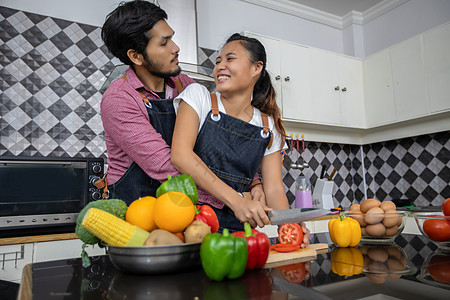 快乐和微笑的年轻夫妇 在家中厨房做饭的食物夫妻女士房子食谱蔬菜男人女性丈夫午餐女孩图片