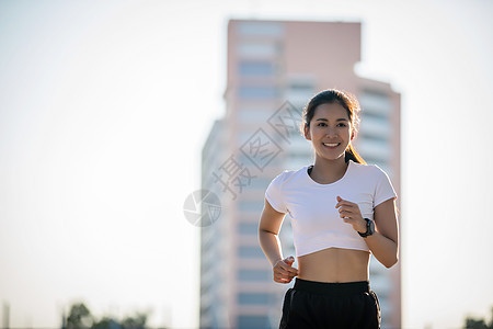 亚裔年轻健身运动女性在城市罗阿奔跑和微笑女士运动员活动活力训练踪迹街道跑步成人耐力图片