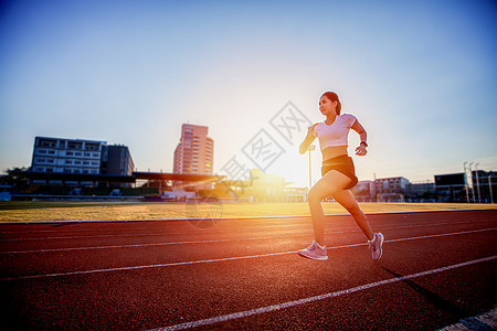 亚裔年青健身女运动员在体育场赛道上跑步成人草地运动服女士阳光生活方式慢跑者运动装健康运动图片