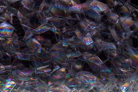 黑色背景气泡中的彩虹圆形液体肥皂宏观圆圈反射洗发水乐趣泡沫图片