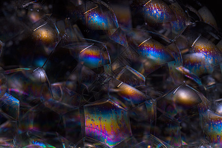 黑色背景气泡中的彩虹液体乐趣圆形宏观泡沫肥皂反射圆圈洗发水图片