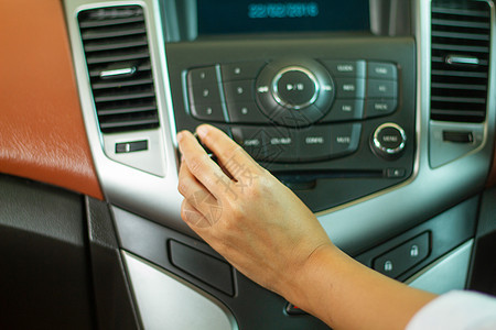 亚洲女性在汽车收音机上监听音乐的按键技术奢华电话皮革车轮控制板调频立体声玩家运输图片