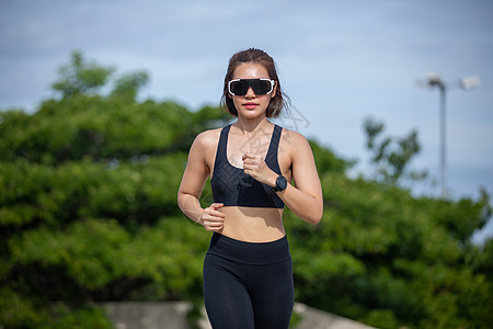 亚裔女性在户外城外奔跑和慢跑森林耐力慢跑者运动员跑步成人赛跑者衣服活力公园图片