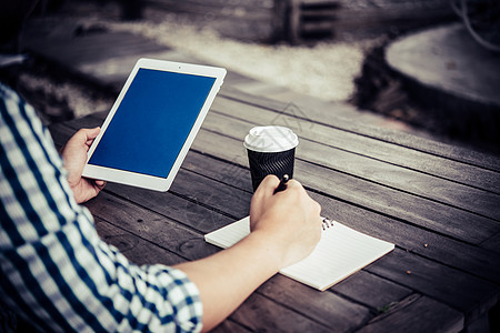 青年男子在喝咖啡时使用数字平板电脑男性商务商业笔记本杯子咖啡人士电子书技术桌子图片
