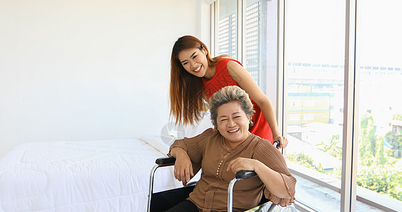 坐在轮椅上照顾外婆的开心女人老年一代女性卫生保健退休婴儿男人家庭女士图片