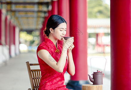 穿旧中国传统服装的亚洲美女 喝水i情感女士旗袍衣服戏服宗教桌子寺庙茶壶大厅图片