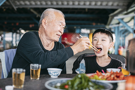 在餐厅喂孙子的外公阿山老爷爷汤匙食物孩子祖父老年筷子男生乐趣退休男人图片
