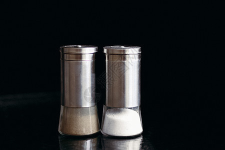 黑色背景的盐和胡椒搅拌器味道用餐矿物调味品厨房金属玻璃饮食食物胡椒图片