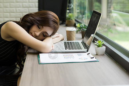 女人在她面前的桌子上睡着睡觉 当着她的面办公室椅子商业电脑商务工人睡眠笔记本工作女士图片