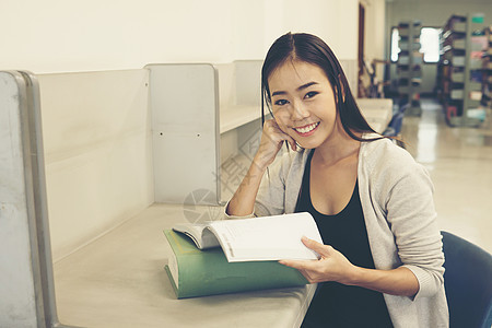 年轻漂亮的亚洲学生在图书馆里读书 教育青少年女性女士学习学校女孩图书大学阅读图片