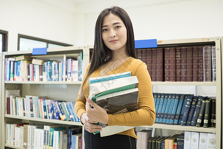 年轻漂亮的亚洲学生对摄影机微笑 教育概念学校女孩大学女性图书女士阅读学习图书馆图片