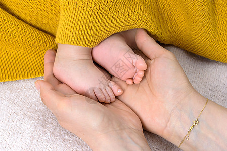 新生儿的婴儿脚掌握在父母手中新生皮肤父亲孩子家庭母亲童年脚趾手指母性图片