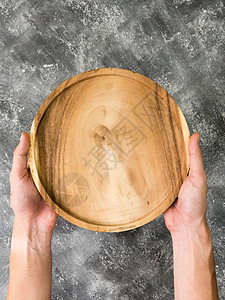 空木质托盘的顶端视图 手放在壁底背景上木板食物烹饪桌子圆形棕色木头餐具盘子厨房图片