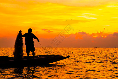 日出时 渔民在湖中捕鱼的轮廓图片