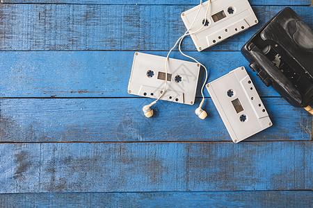 Cassette 播放器的顶部视图 其音频带在蓝色木制表格背景上收音机播送均衡器娱乐嗓音立体声记录塑料录音机桌子图片