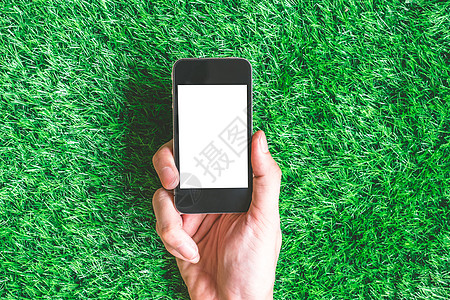 男性手拿着智能手机 在绿色草原背景背景图片