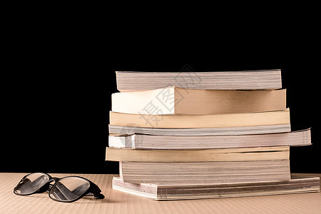 黑背景 木板上堆满书本和眼镜故事智慧桌子书店图书馆文学教科书知识字典历史图片