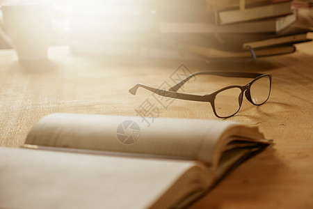 眼镜贴近 书放在木桌 有选择的焦点 明亮的太阳光和风声上图片