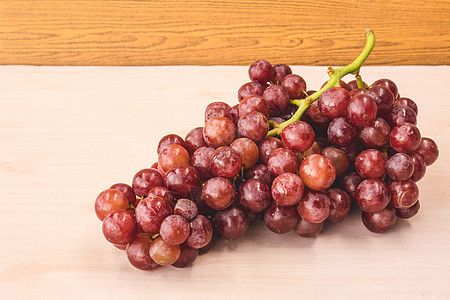 红葡萄在木制桌上图片