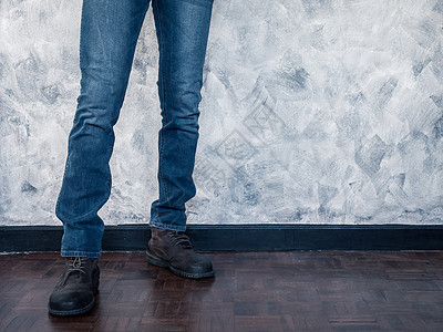 穿着牛仔裤和木制地板靴子的曼腿紧贴处 免费文字空间男性皮革鞋带蓝色裤子鞋类牛仔布男人地面衣服背景图片