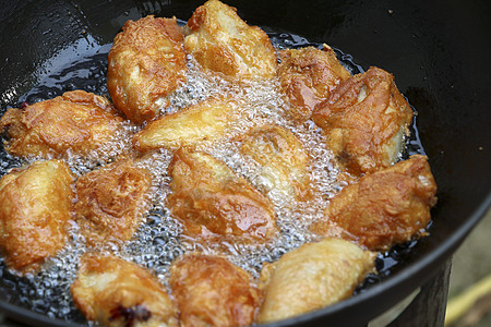 锅里有热油的炸鸡 锅里有金黄炸鸡平底锅煎锅午餐火炉泡沫翅膀润滑脂食物烹饪脂肪图片
