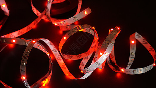 黑色背景的红引导照明 LED 带技术水晶磁带活力发射电子产品绳索白色辉光条纹图片