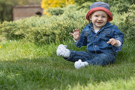 坐在草地外的小小男孩子图片