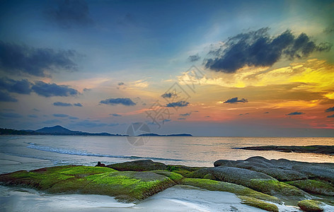 日出或日落时多彩的云层背景海岸海浪海滩异国天空石头阳光假期海景天堂图片