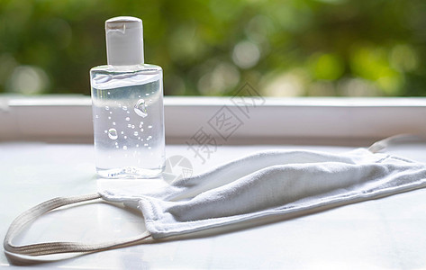 白桌上的洗手清洗剂和面罩图片