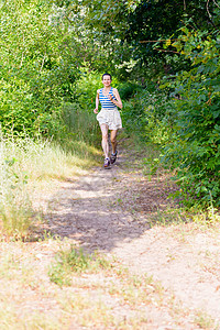 在森林中奔跑的年长女子树木跑步女士途径森林农村公园赛跑者慢跑小路图片