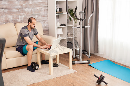 男子在家中穿运动服 在线体操培训成人互联网刚度房间训练力量电脑运动运动装身体图片