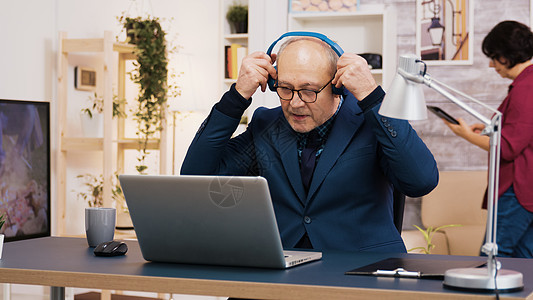 老人老人在耳机上听音乐冲浪监视器头发互联网男人电视客厅老年电脑成人图片