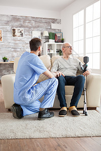 疗养院的年轻医生与老人交谈护理照顾者退休老年人员男人保健长老拐杖医学图片