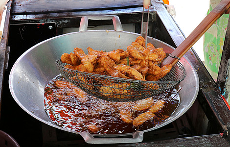 油锅加热油油炸香蕉 泰国亚裔轻松食品街的香蕉炒香料食物味道叶子甜点水果筹码盘子小吃美食图片