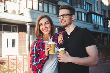 快乐的情侣在街上漫步 喝着咖啡饮料街道微笑女性朋友们女朋友女孩男性男人家庭图片