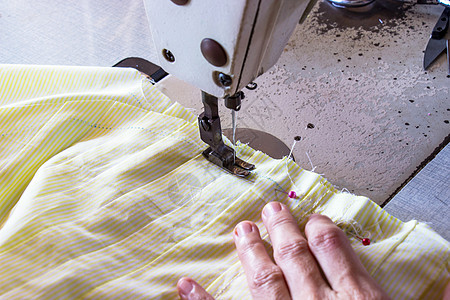 女性在缝纫机上工作的裁缝手掌图片