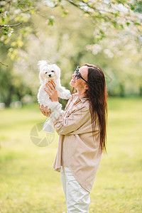 女人在公园里玩耍和抱抱小狗幸福快乐游客女孩动物天气友谊朋友女士娱乐图片