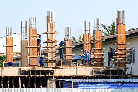 建筑工地和建筑工人区 人们正在施工 一群人是专业建筑工人 劳工工人头盔劳动者房子梯子工程团体工艺材料金属蓝色图片