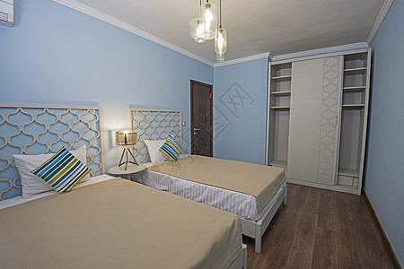 豪华公寓卧室的内地桌子枕头衣柜木地板双人床木头装饰床头板家具设计图片