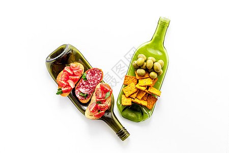 在白桌顶视图的表格中将瓶子作为餐桌上的美酒开胃乐图片