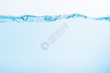 蓝色水浪表面在白色背景上喷洒海浪波纹水滴流动气泡液体宏观图片