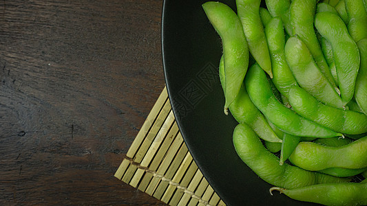 Edamame在黑色板块上显示食物含量的最高视图图像营养豆类蔬菜大豆饮食美食绿色小吃桌子毛豆图片