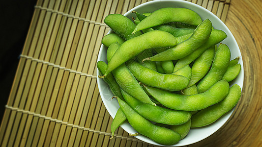 用沸水煮沸毛豆Edamame在白碗中展示食物内容的顶端视图图像大豆桌子美食饮食绿色蔬菜毛豆营养豆类小吃背景