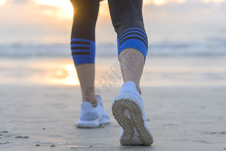 日出时在沙滩上跑的女子 在鞋上紧贴赛跑者跑步女孩慢跑自由慢跑者速度日落护理训练图片