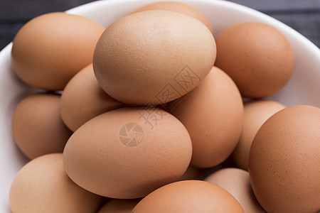 在木桌上用白碗把新鲜的母鸡 关上蛋壳动物美食产品团体脆弱性烹饪宏观椭圆形早餐图片