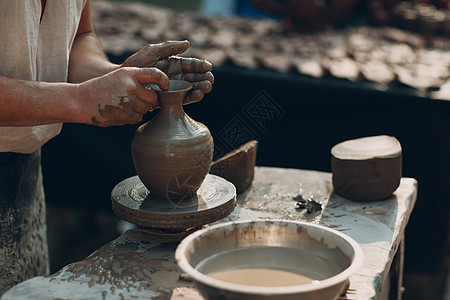 波特在陶器车轮上制造泥锅罐图片